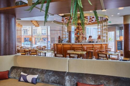 a restaurant with a bar with tables and chairs at voco Paris - Porte de Clichy by IHG in Clichy