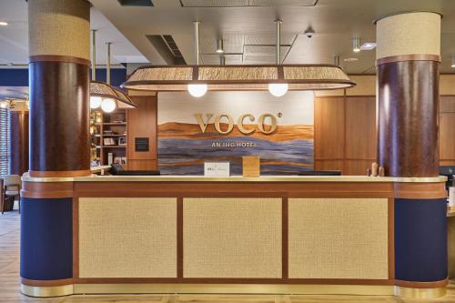 an office lobby with a voco sign on the wall at voco Paris - Porte de Clichy, an IHG Hotel in Clichy