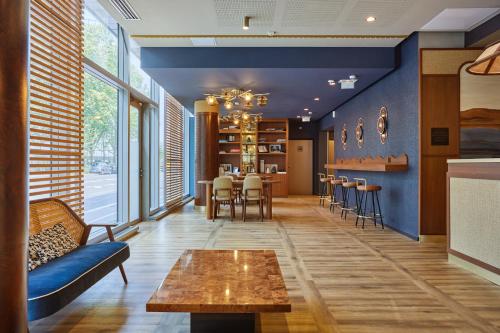 - un salon avec des murs bleus, une table et des chaises dans l'établissement voco Paris - Porte de Clichy, an IHG Hotel, à Clichy