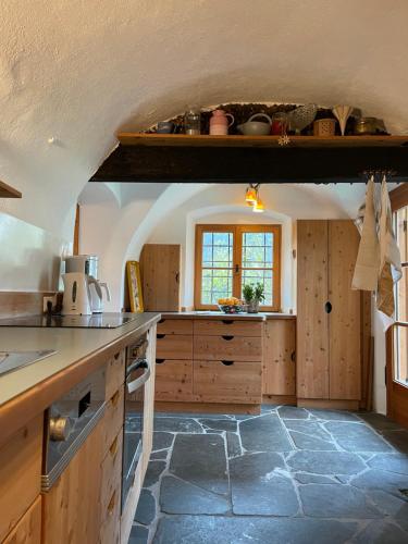 una cucina con armadi in legno e pavimento in pietra di Klösterle Haus Resi ad Arriach