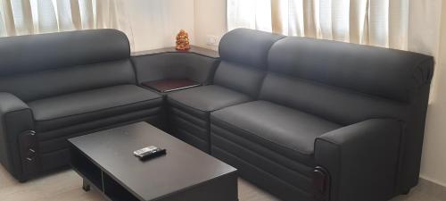 a living room with a couch and a table at The Candy Nest in Rānchī