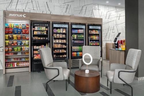 a grocery store with two chairs and a table and drinks at Residence Inn by Marriott New York Queens in Queens