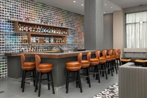 a bar with a row of orange bar stools at Residence Inn by Marriott New York Queens in Queens