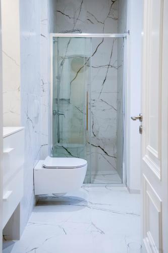 a bathroom with a toilet and a glass shower at Psaradika Apartment Modern Comfort in Corfu Old Town in Corfu