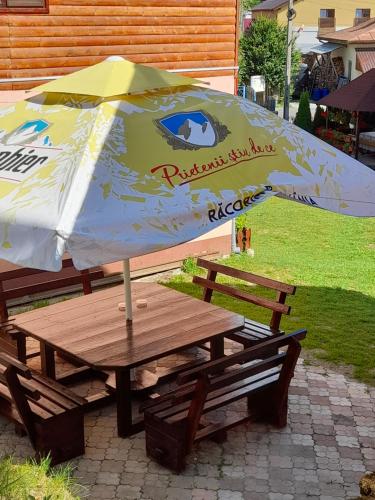 a picnic table with an umbrella on top of it at Cabana Med 2 in Arieşeni