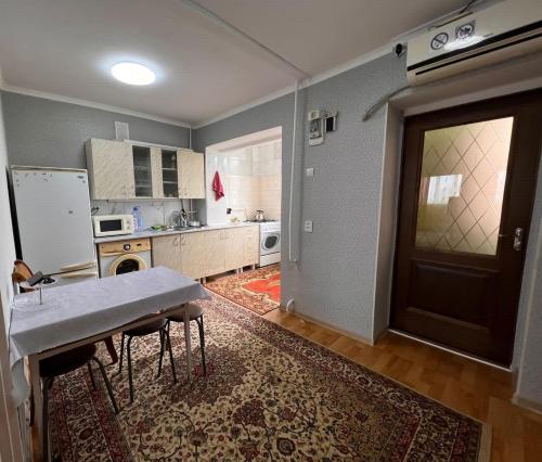 a kitchen with a table and a door in a room at квартира 11 дом in Aktau