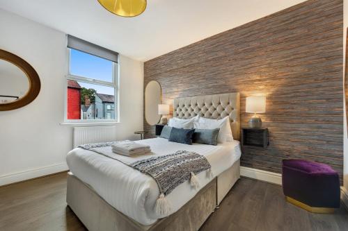 um quarto com uma cama grande e uma parede de tijolos em Host & Stay - The Kensington Townhouse em Liverpool
