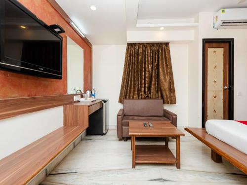 a room with a bed and a couch and a table at HOTEL BALWAS in Surat