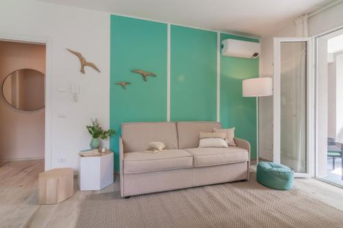 a living room with a couch and birds on the wall at Ninfea Apartments by Wonderful Italy in Lezzeno