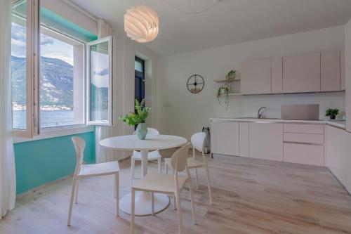 a kitchen and dining room with a table and chairs at Ninfea Apartments by Wonderful Italy in Lezzeno