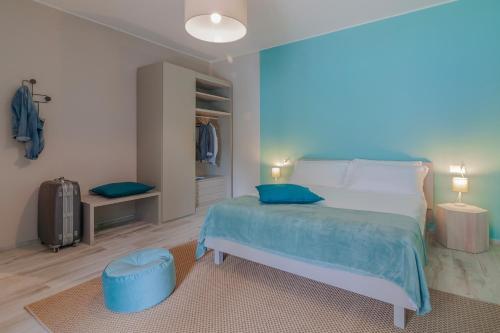 a bedroom with a bed with blue sheets and blue pillows at Ninfea Apartments by Wonderful Italy in Lezzeno