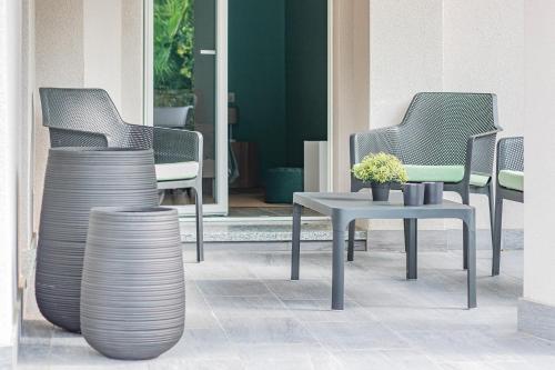 a group of chairs and a table on a patio at Ninfea Apartments by Wonderful Italy in Lezzeno