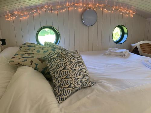 Oak Tree Lodge: Unique 2 level Shepherd's Hut: Dartmouth في دارتموث: غرفة نوم عليها سرير ووسادتين