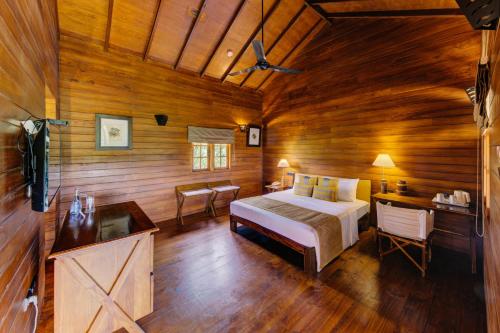 1 dormitorio con 1 cama en una habitación de madera en Cinnamon Wild Yala, en Yala