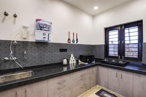 a kitchen with a counter top and a window at StayVista's La Villa Farm - Tranquil Retreat with Outdoor Pool, Games & Terrace in Mohāna