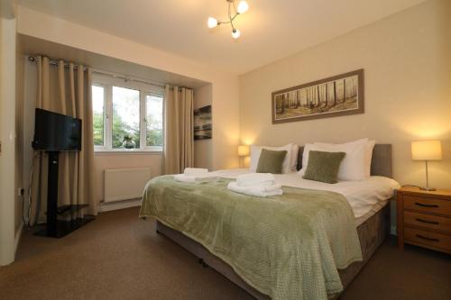 a bedroom with a large bed and a television at Signature - Angus House Glasgow in Glasgow