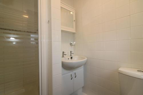a white bathroom with a sink and a shower at Signature - Angus House Glasgow in Glasgow