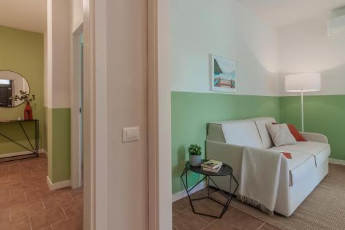 a living room with a white couch and a table at Ninfea Apartments by Wonderful Italy in Lezzeno