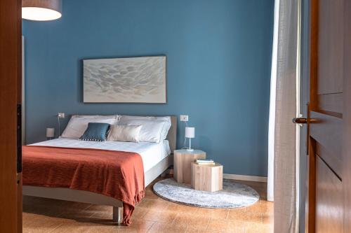 a blue bedroom with a bed with a blue wall at Ninfea Apartments by Wonderful Italy in Lezzeno