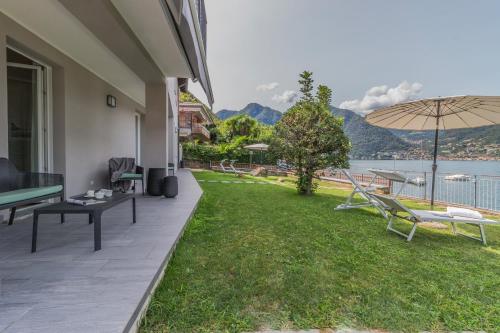 a patio with a view of the water at Ninfea Apartments by Wonderful Italy in Lezzeno