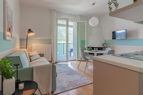 un soggiorno con divano e tavolo di Ninfea Apartments by Wonderful Italy a Lezzeno