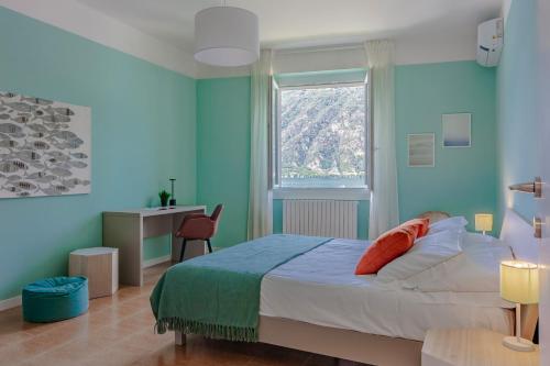 una camera blu con un letto e una finestra di Ninfea Apartments by Wonderful Italy a Lezzeno