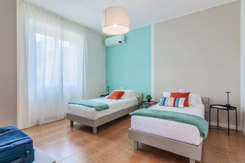 a bedroom with two beds and a blue wall at Ninfea Apartments by Wonderful Italy in Lezzeno