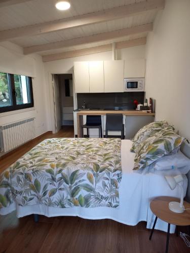 a large bed in a room with a kitchen at Finca Bacelo Ribeira Sacra in Sober
