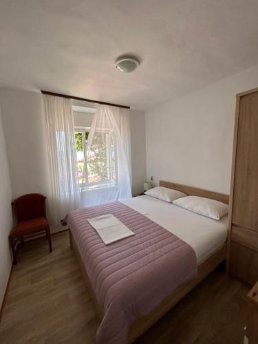 a bedroom with a large bed and a window at Sobe Gorana in Živogošće