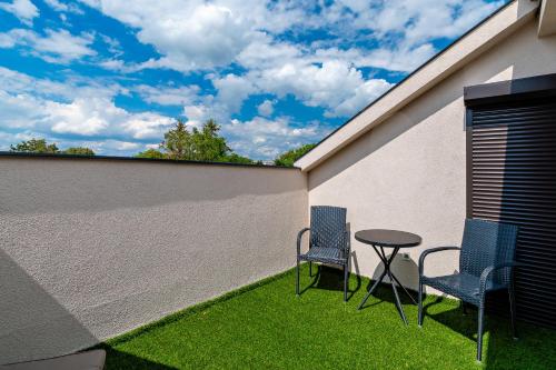two chairs and a table next to a wall at Diamond Panzió in Hajdúszoboszló