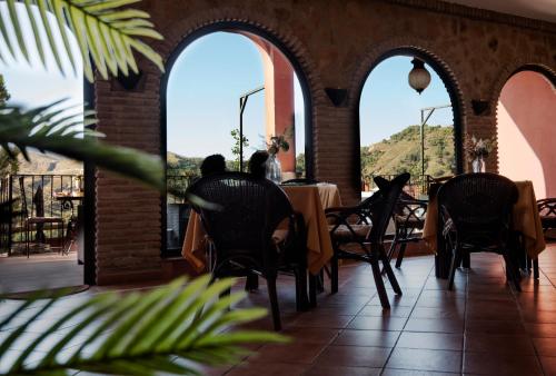 a couple sitting at a table in a room with windows at Hotel Boutique Cerro del Sol Adults only recommended in Granada