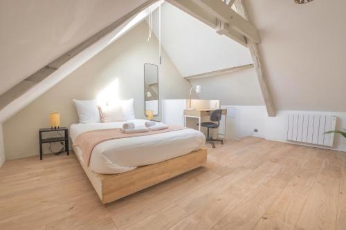 - une chambre mansardée avec un lit et un bureau dans l'établissement Triplex cosy, à Reims
