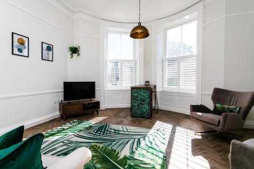 a living room with a couch and a tv at Tyne Square North Shields - historic property - dog friendly in North Shields