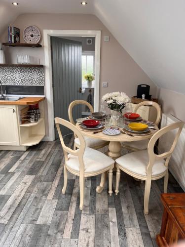 a dining room with a table and chairs at The Honeysuckle Coop in Grantham