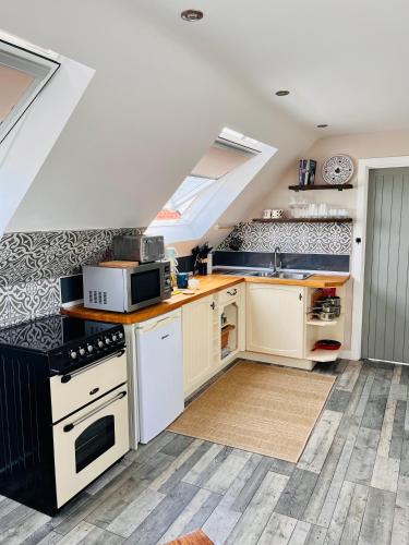 a kitchen with white cabinets and a sink at The Honeysuckle Coop in Grantham