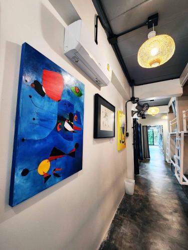 a hallway with a painting on the wall at Baan Mai Kradan Hostel Chiang Rai in Chiang Rai