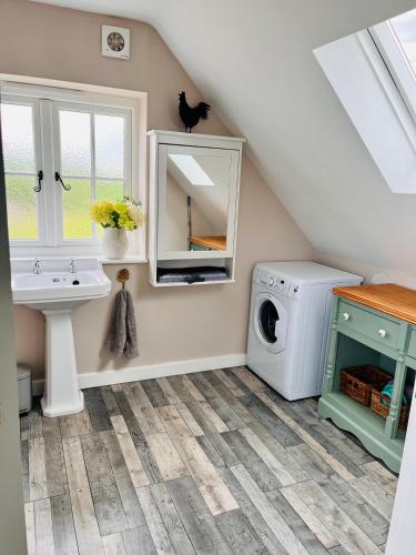 a bathroom with a sink and a washing machine at The Honeysuckle Coop in Grantham