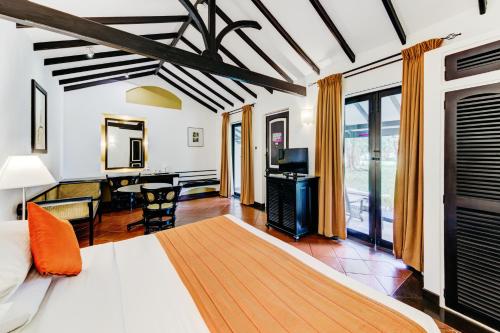 a bedroom with a bed and a desk and a table at Cinnamon Lodge Habarana in Sigiriya