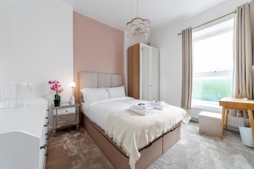 West Dulwich的住宿－Fantastic 2BR flat wgarden, West Norwood，一间白色卧室,配有一张床和浴缸
