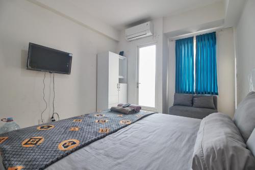 a bedroom with a bed and a flat screen tv at Room Rendi Podomoro Golf View in Taladjurg-udik