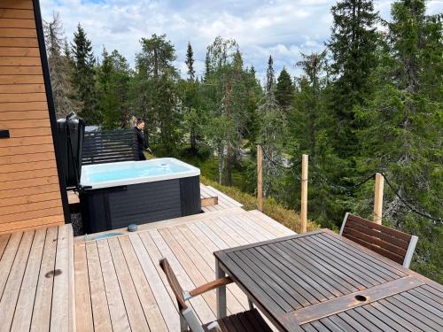 a deck with a hot tub and a table and chairs at Villa Dakota in Syöte