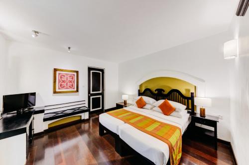 a bedroom with a bed and a flat screen tv at Cinnamon Lodge Habarana in Sigiriya