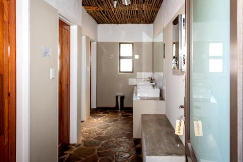 ein Badezimmer mit einem Waschbecken, 2 Waschbecken und einem Spiegel in der Unterkunft At Kronenhof Campsites in Sesriem