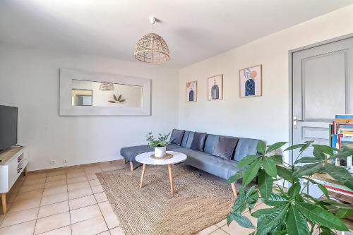 - un salon avec un canapé bleu et une table dans l'établissement LE TOLOSANA - Appartement 4 personnes - Centre WiFi Cosy, à Saint-Gilles
