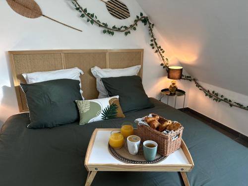 Una cama con una bandeja con una cesta de comida. en Jungle suite - moderne et spacieux, en Annecy