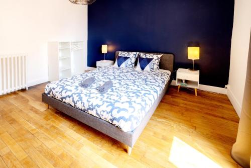 a bedroom with a large bed with a blue wall at Spacieux T3 centre ville in Montluçon