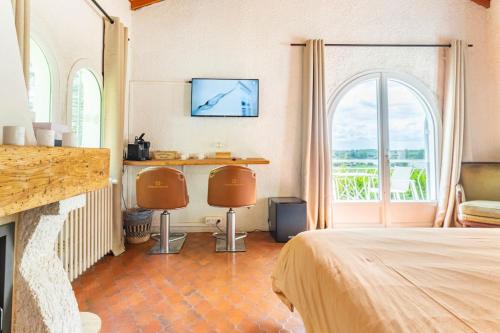 a bedroom with a bed and a fireplace with two chairs at 1986MALAGAR in Baurech