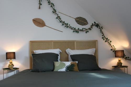 1 dormitorio con 1 cama con almohadas y 2 lámparas en Jungle suite - moderne et spacieux, en Annecy