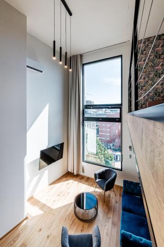 a living room with a table and a large window at VV hotel & apartments in Brno