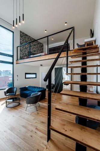 a living room with stairs and a blue couch at VV hotel & apartments in Brno